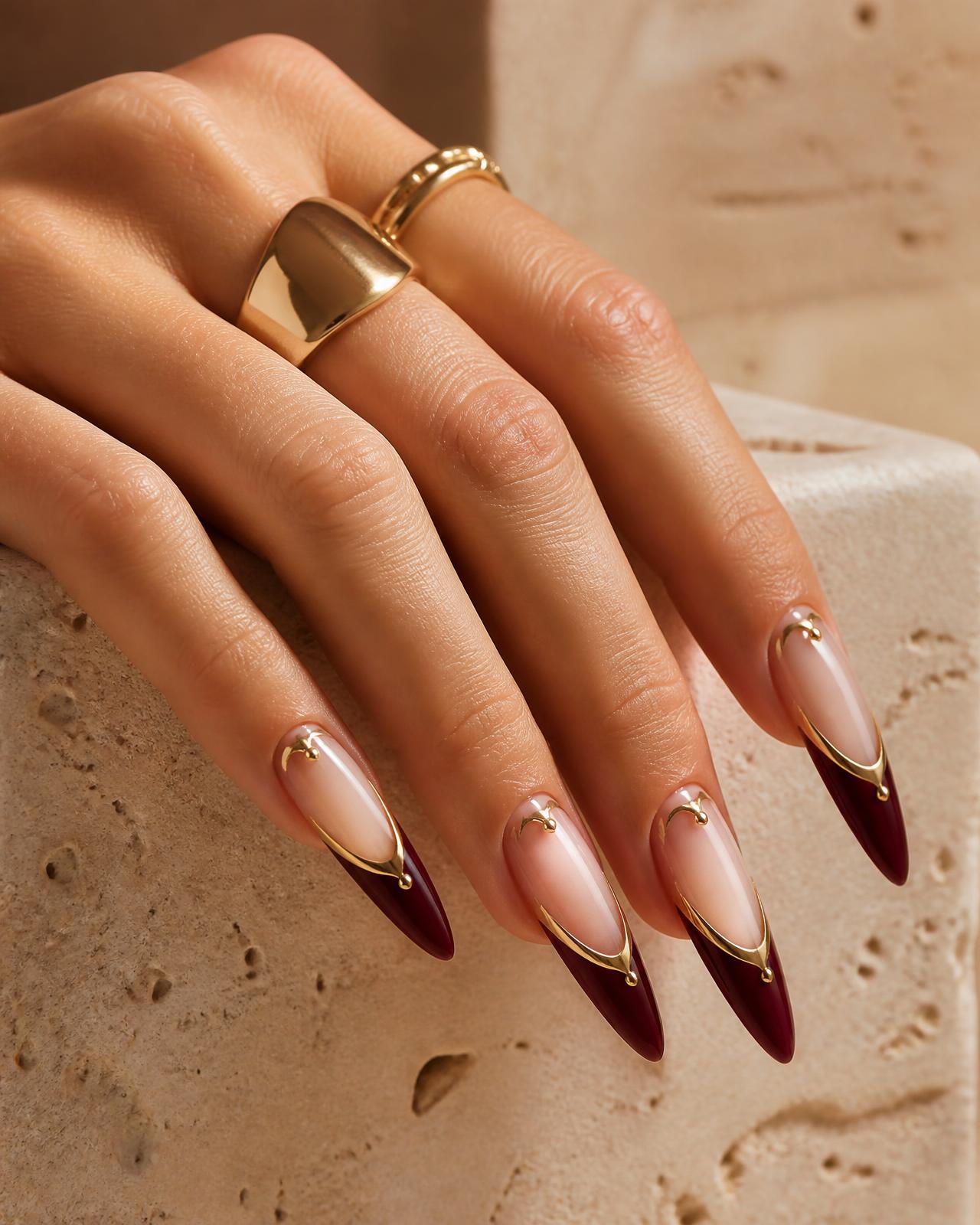 Ongles longs en amande avec French bordeaux et détails dorés